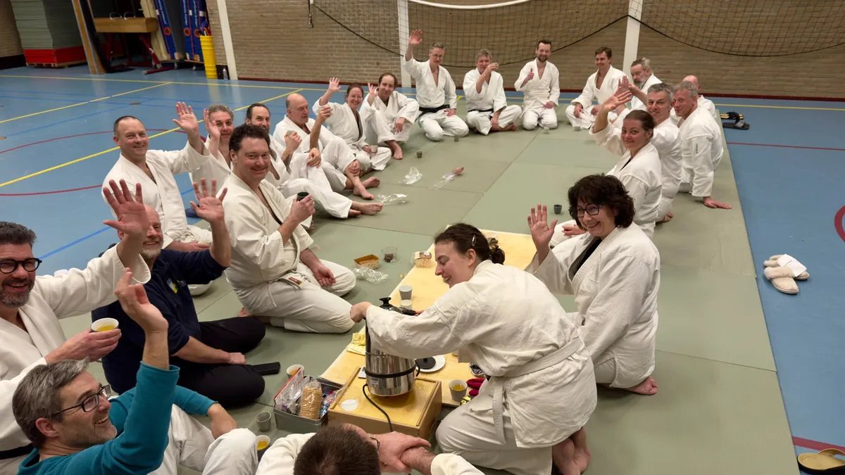 Leden van Ima Juku zitten samen op de mat na de training